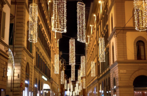 A vibrant Italian street scene showcasing twinkling lights, the streetscape adorned with Christmas lights for the holiday season.